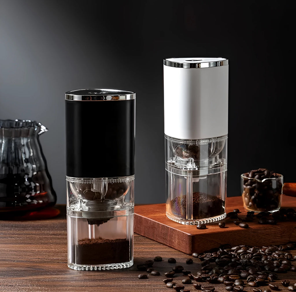 Black and white portable electric coffee grinder with USB charging cable on a kitchen counter.