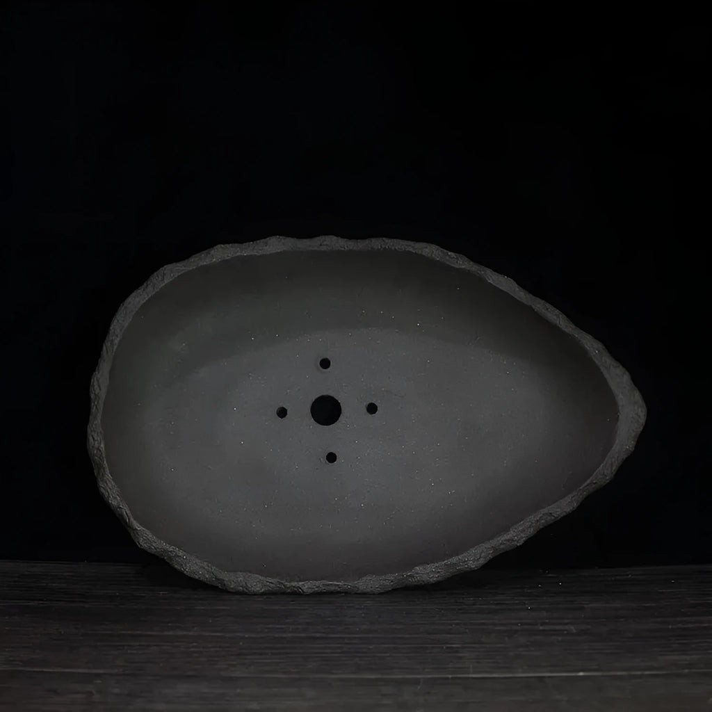 Handmade purple clay flower pot showing unique shape and texture