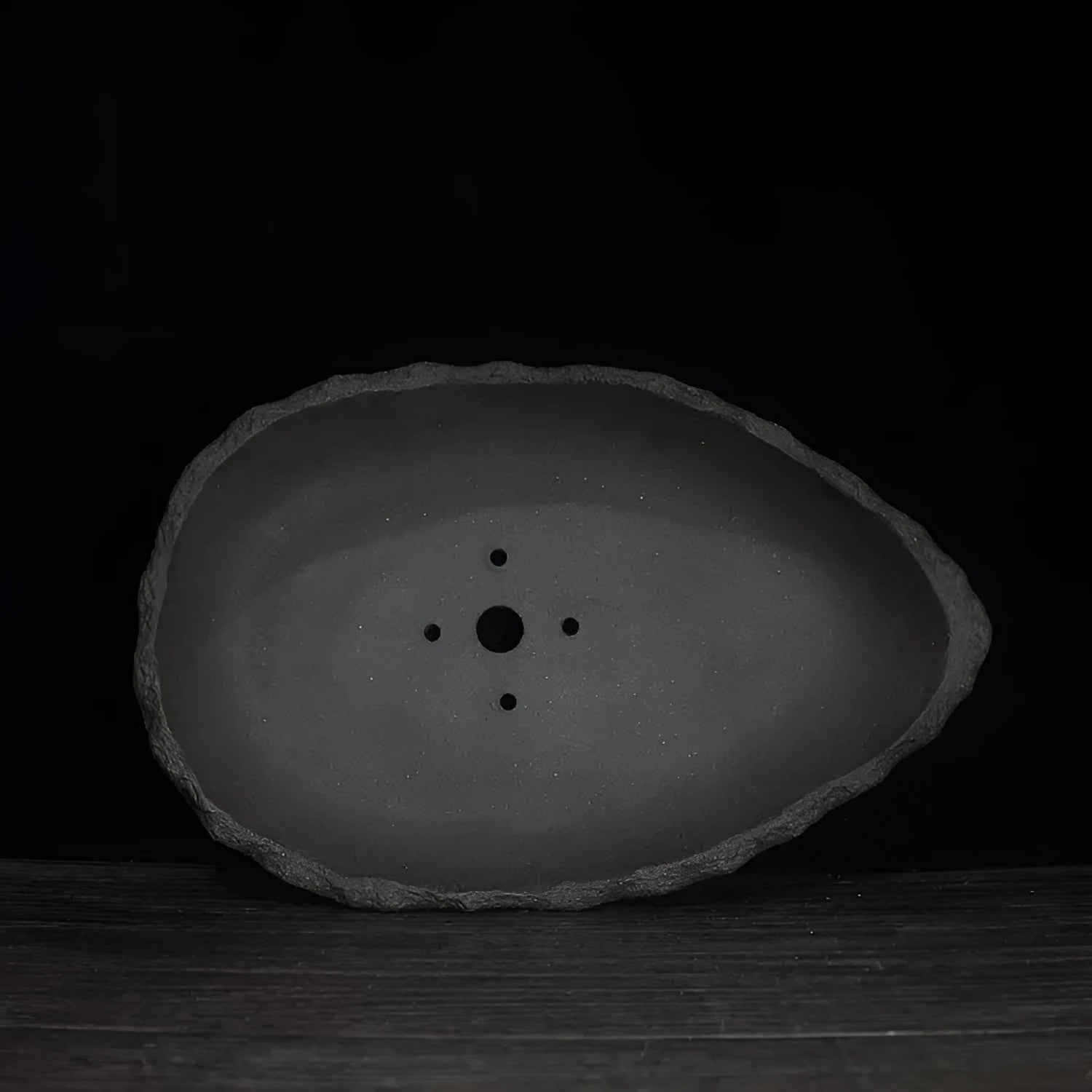 Handmade purple clay flower pot showing unique shape and texture