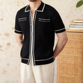 Man's slim-fit black knitted polo shirt with a lapel collar and short sleeves.