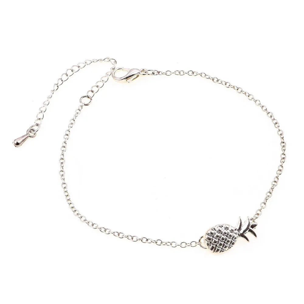 Women's alloy pineapple charm bracelet in gold or silver colour on a wrist.