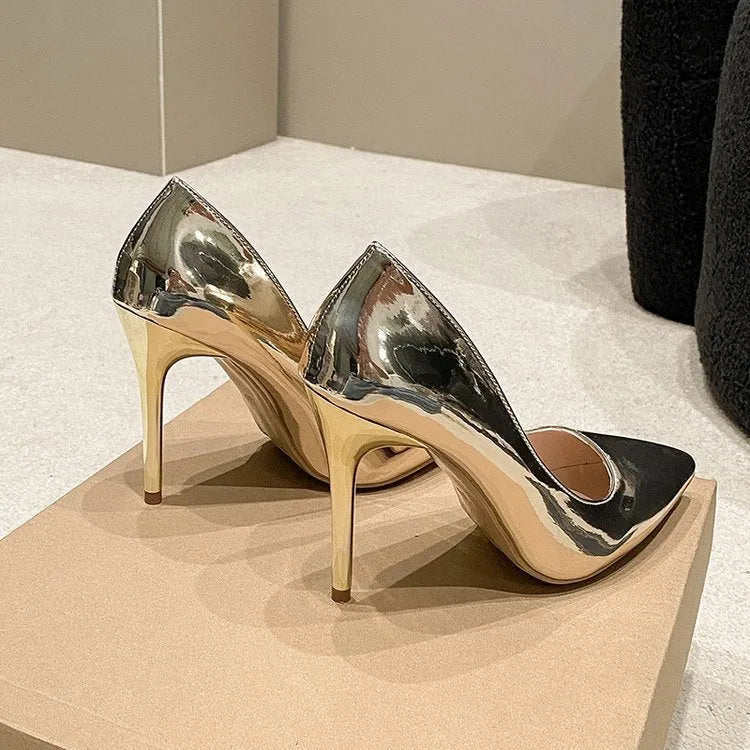Gold and silver pointed toe slip-on pumps with stiletto heel on white background
