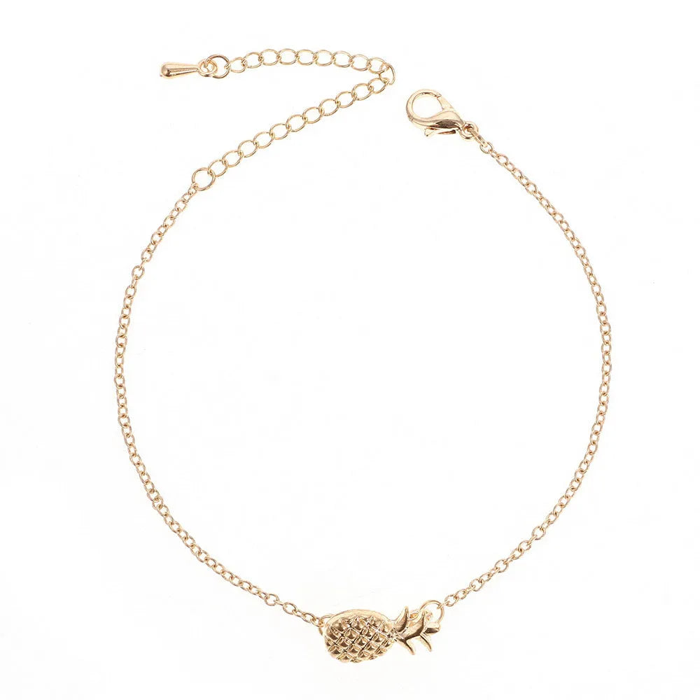Women's alloy pineapple charm bracelet in gold or silver colour on a wrist.