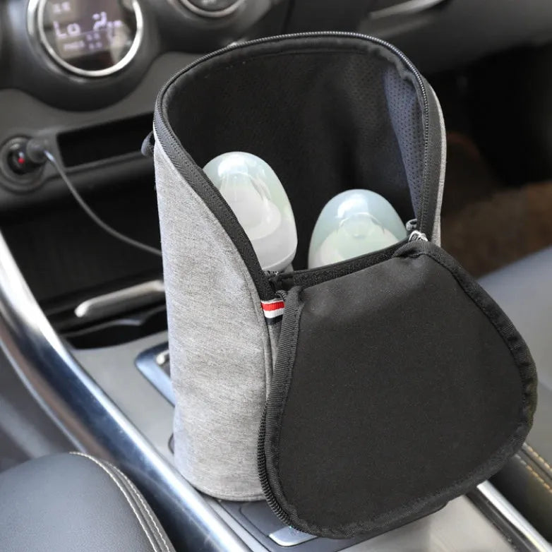 Grey Oxford cloth portable baby bottle warmer with electronic display and car charger, shown next to two baby bottles.