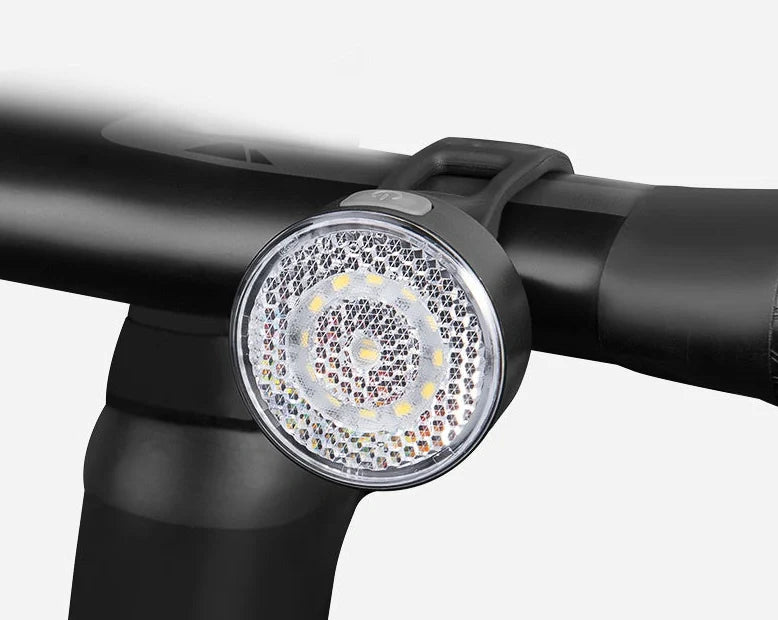 Bicycle LED headlight with clip attachment showing lens reflectors and USB port for charging