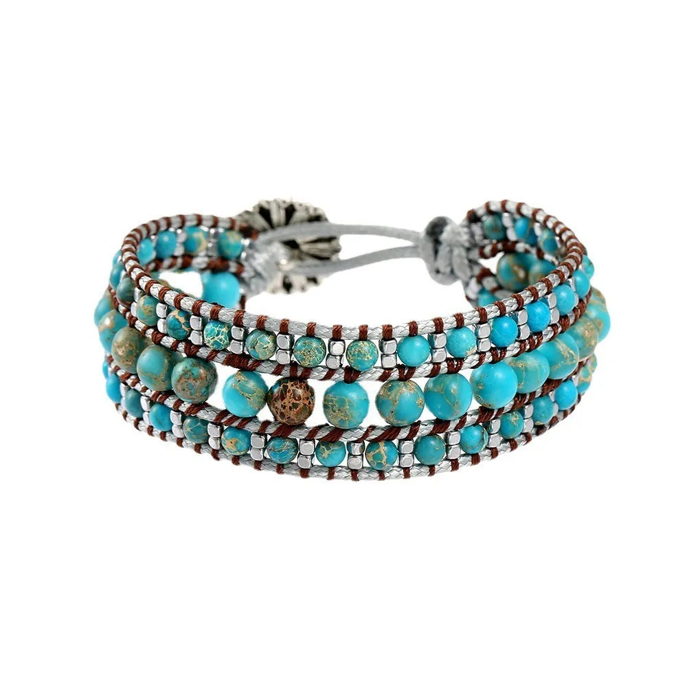 Handmade turquoise geometric inlaid gem bracelet in green with starry sky meteor shower pattern on a white background.