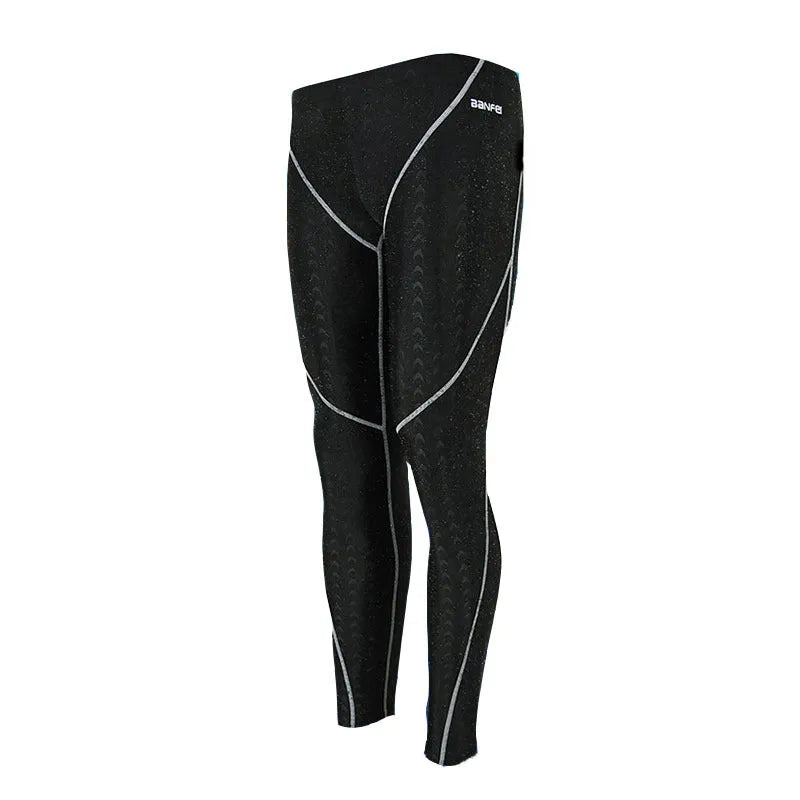 Men's black and grey cropped nylon swimming trunks with mesh lining laid flat.
