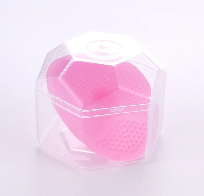 Silicone facial brush in three bristle zones with suction cup on blue background