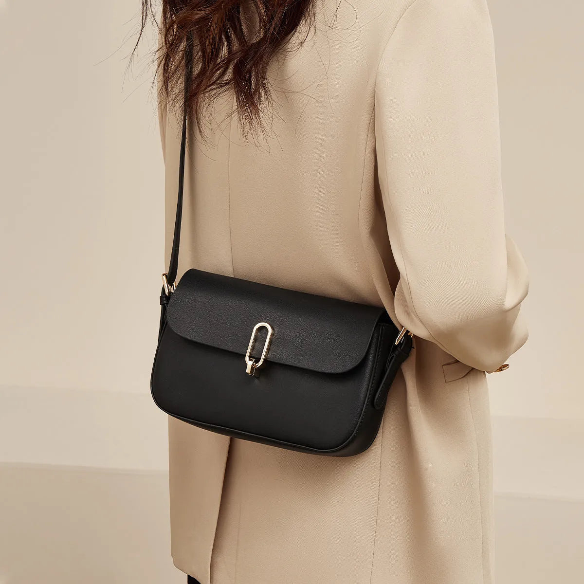 Square leather messenger bag in black with shoulder strap and lock fastener
