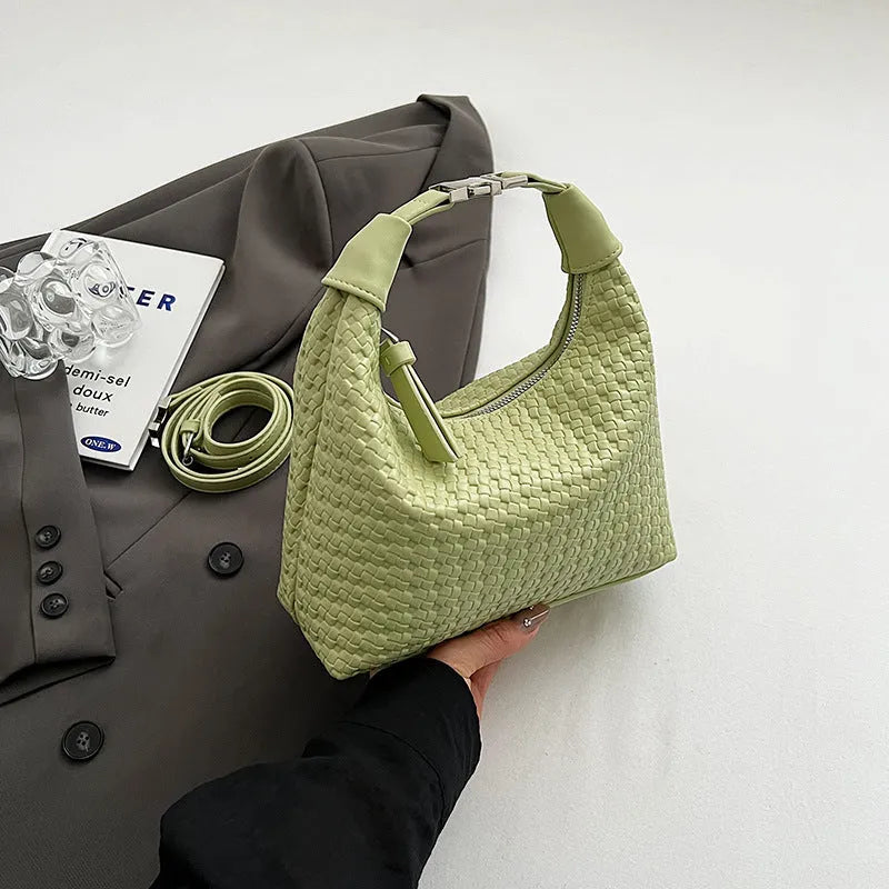 Soft beige PU bucket-shaped messenger bag with an external pocket, shown open to reveal internal document organiser.
