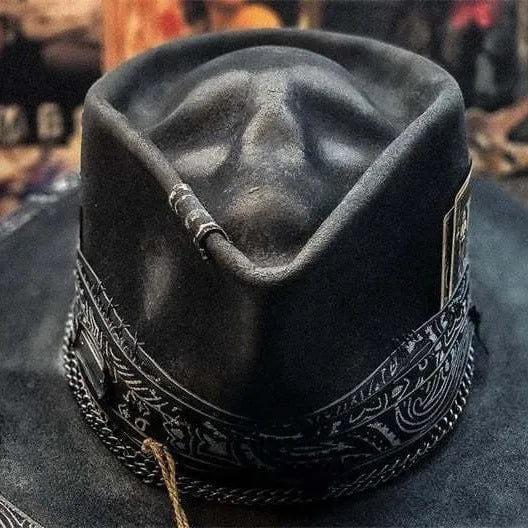 Handmade wool felt hat with conical crown and skull embroidery on a denim base.