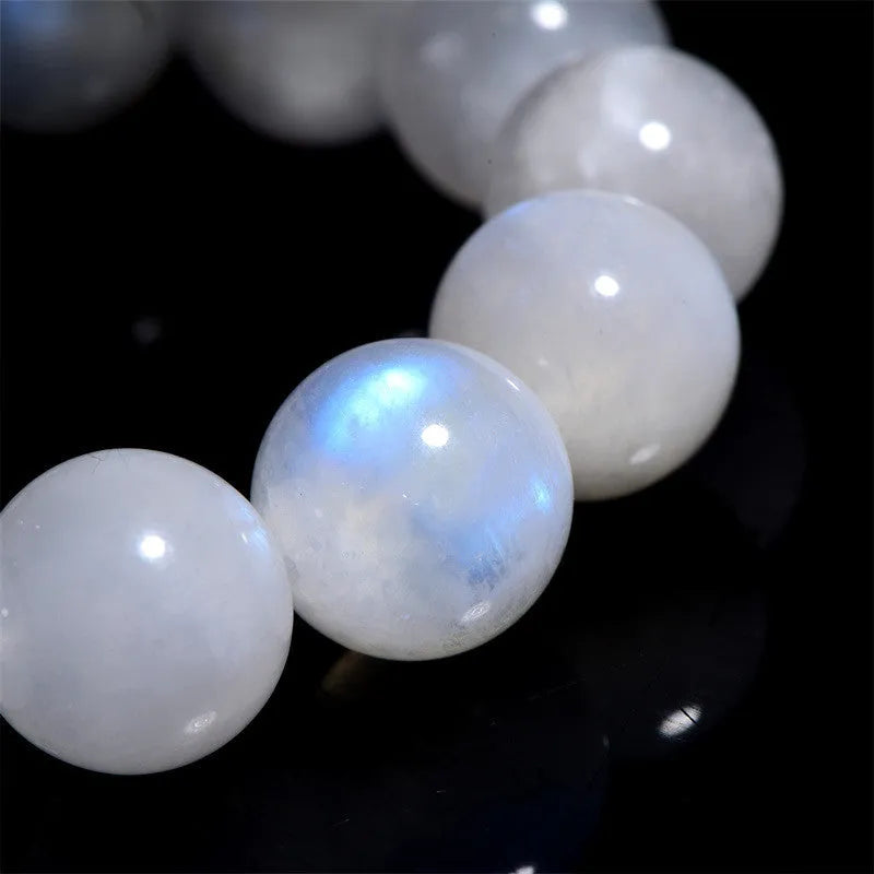 Natural blue moonlight round bead moonstone bracelet in white, showing polished stone surface.
