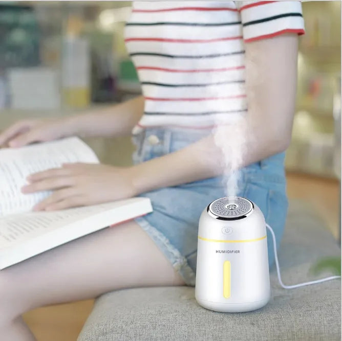 Mini ultrasonic humidifier 330ml four-in-one USB with LED light and fan in blue, pink and white on desk