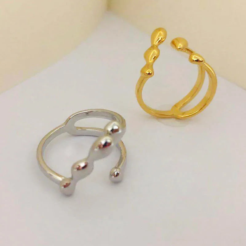 Gold and silver brass women's fashion ring with spherical design detail.