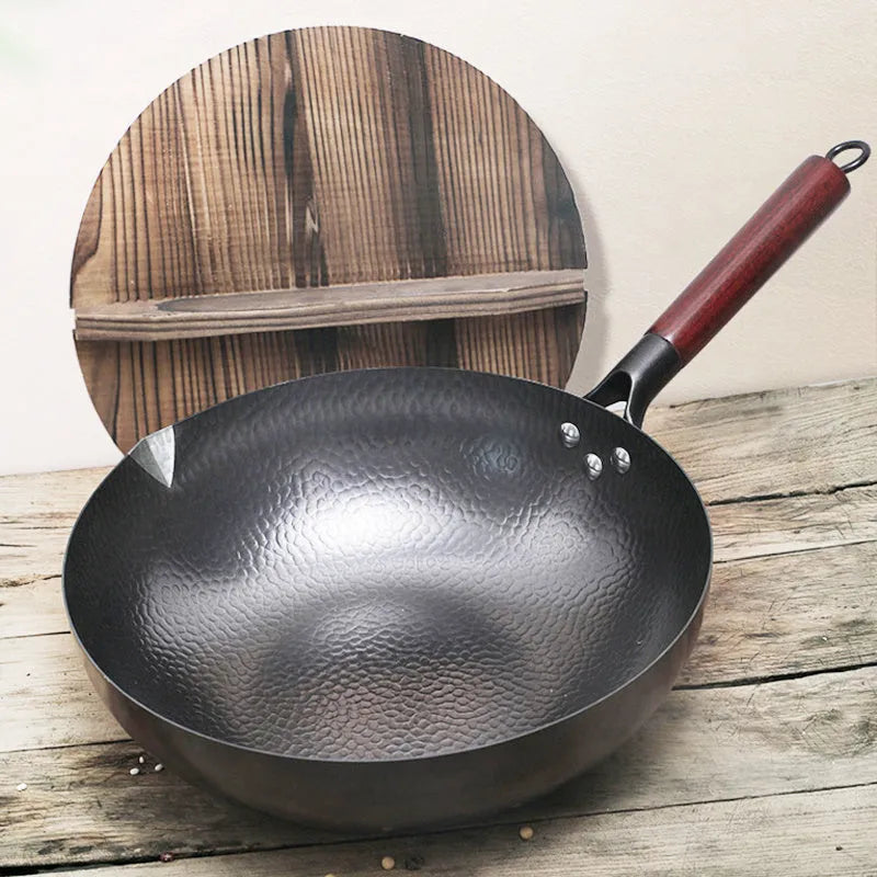 Traditional black iron wok pan with wooden handle measuring 40x32x10cm