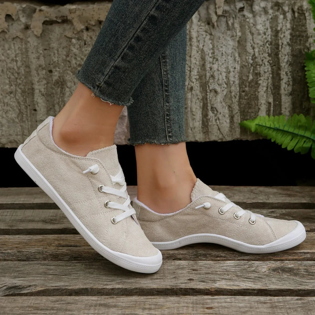 Women's creamy white low-top fabric sneakers with a casual rubber sole on a neutral background