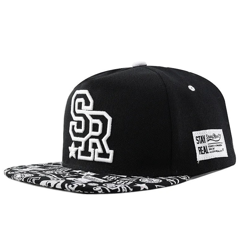Black and white cotton baseball cap with letter embroidery on the front, showing adjustable strap at back.