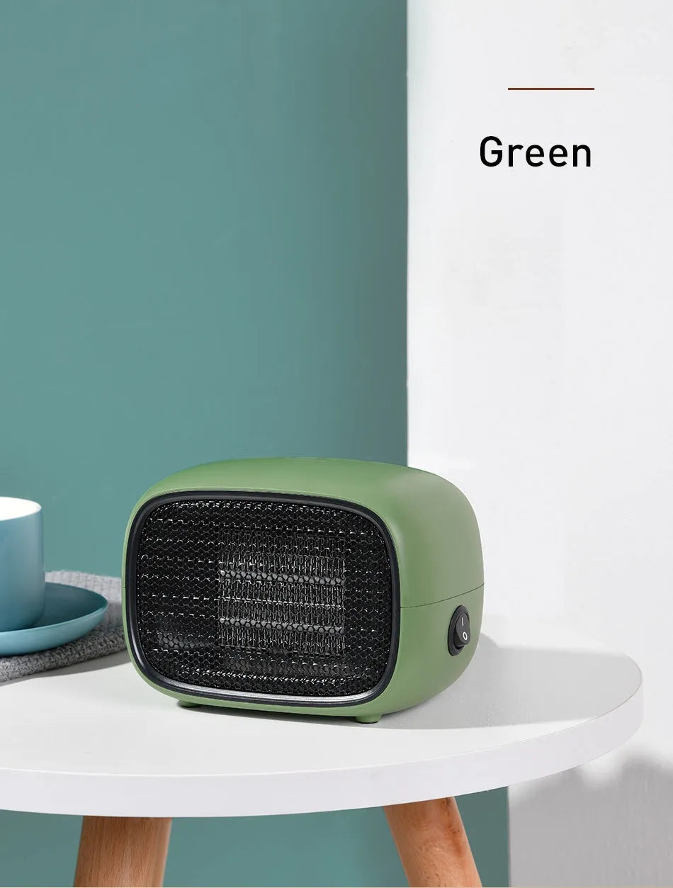 Compact green portable ceramic fan heater on a wooden desk