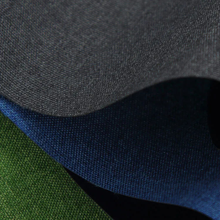 A black, blue, and green polyester ant cloth laid flat, used as a protective cover on a piece of luggage.
