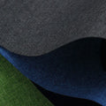 A black, blue, and green polyester ant cloth laid flat, used as a protective cover on a piece of luggage.