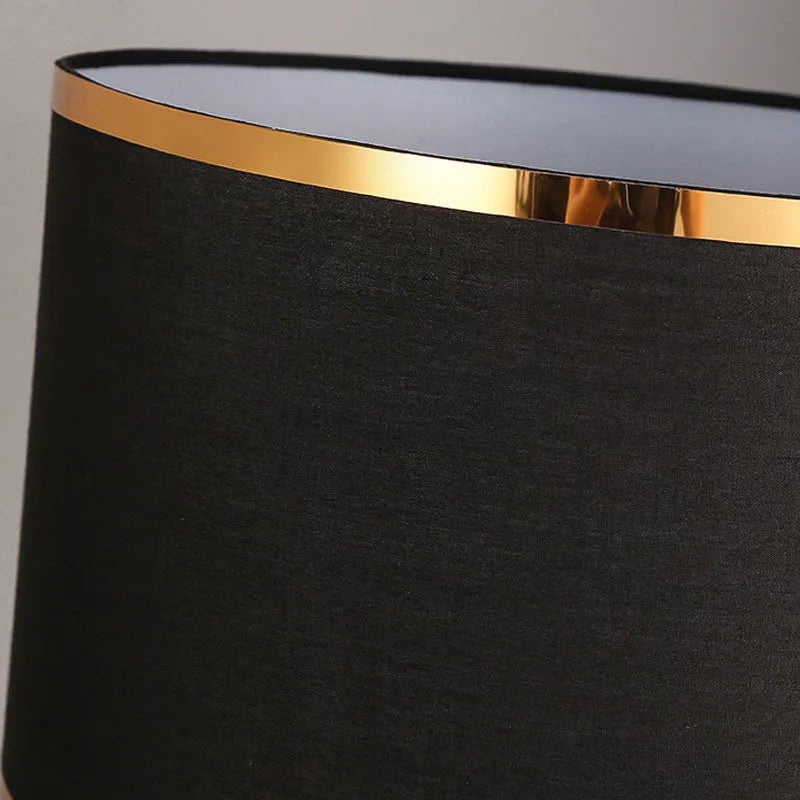 Simple iron table lamp with a fabric shade in black, gold, or white colour options.
