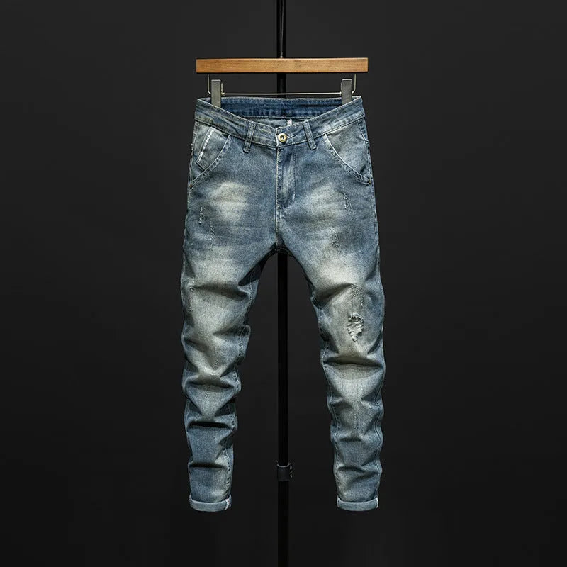 Men's slim-fit dark blue cotton denim jeans with a mid-waist and ankle-length leg.