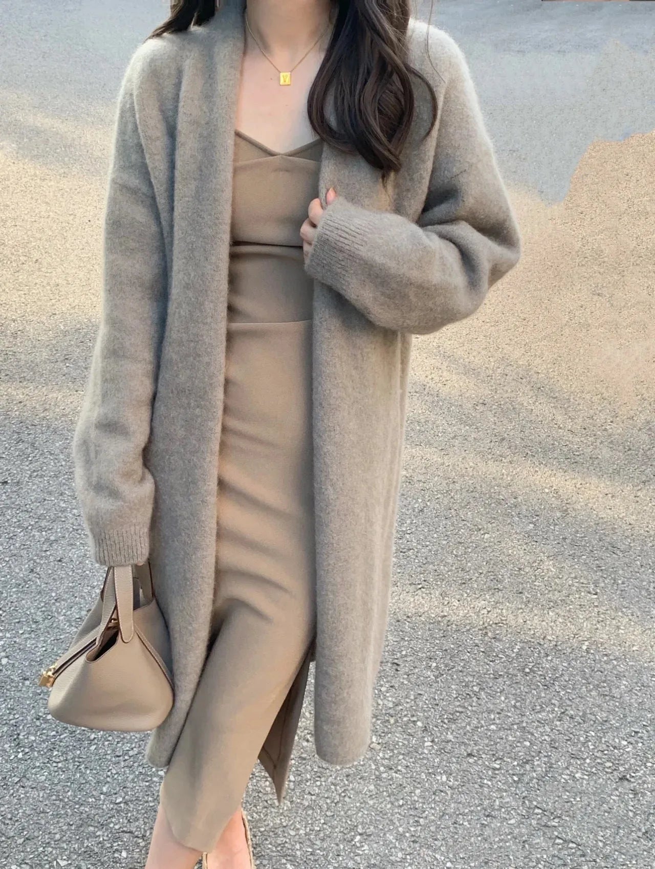 Women's khaki loose-fit knitted V-neck cardigan on a hanger, showing mid-length and long sleeves.