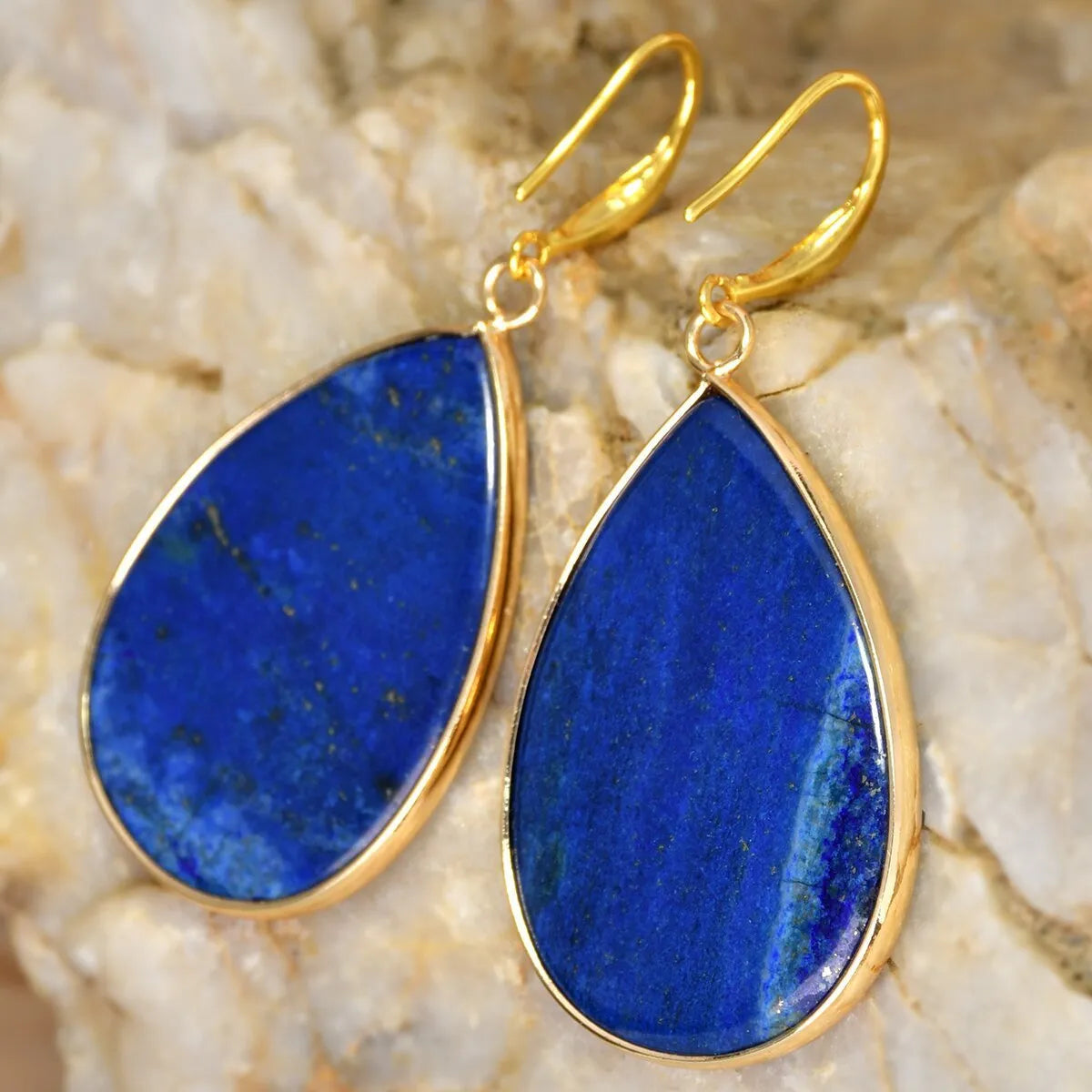 Close-up of women's retro water drop pendant earrings made from natural stone in a selection of colours.