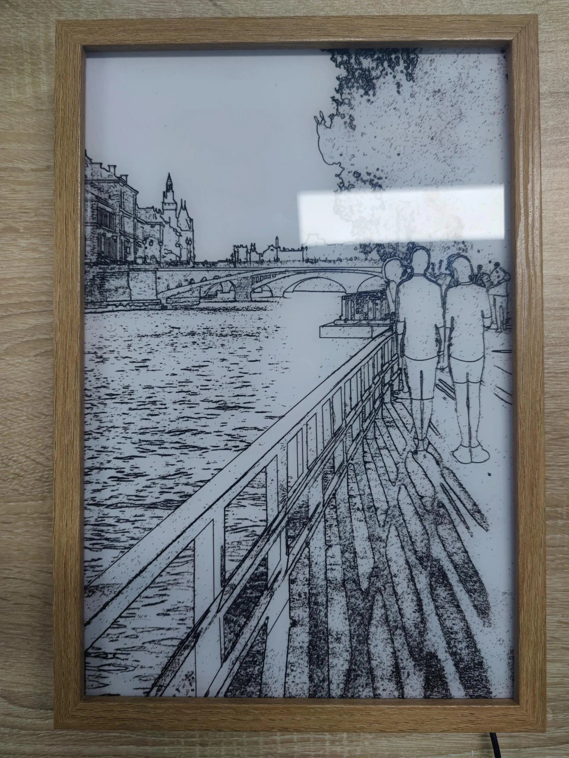 Illuminated LED decorative picture frame showing a scenic print with soft backlighting, featuring a wooden frame and a button switch.