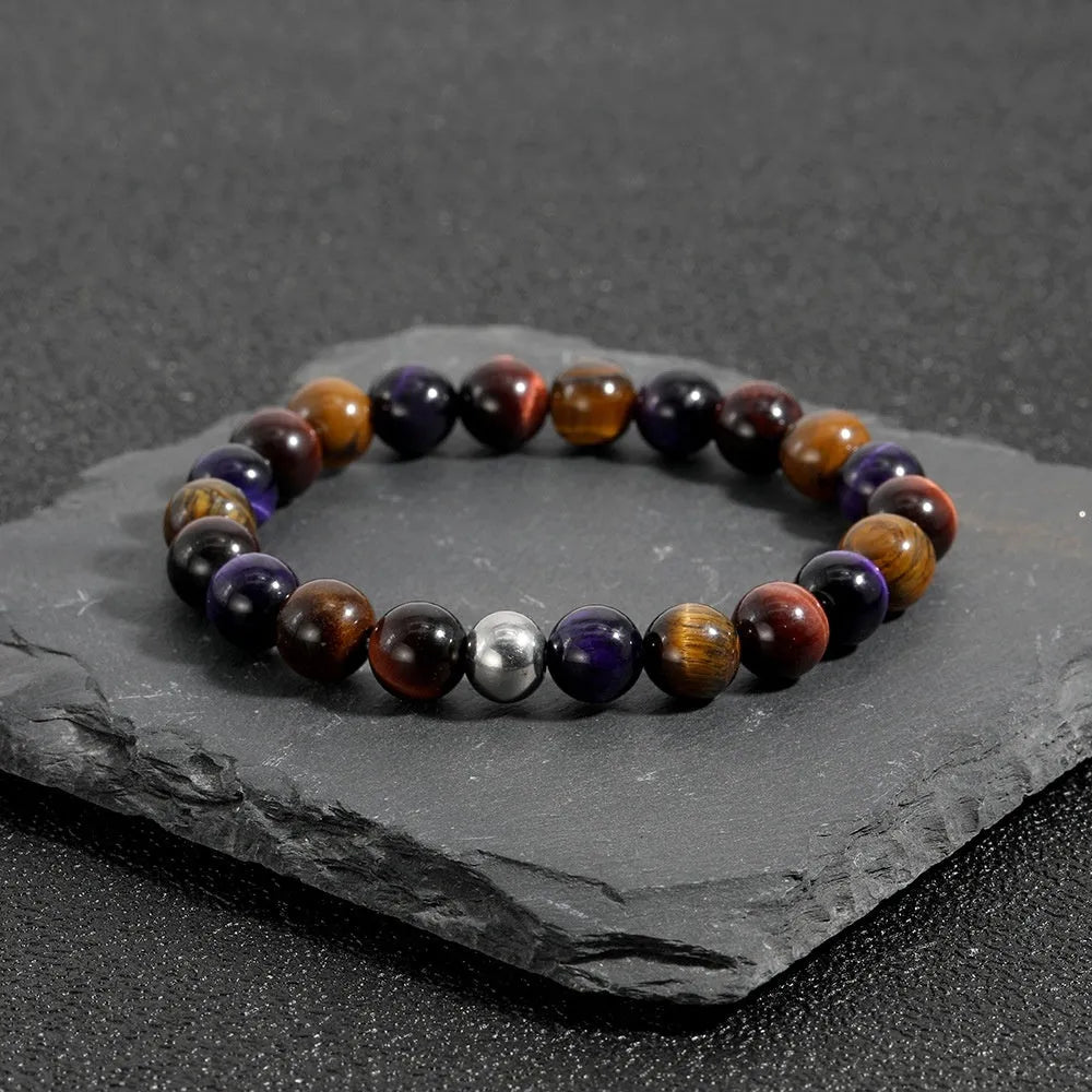 Handmade elastic tiger-eye stone bracelet in geometric shapes on a wrist.