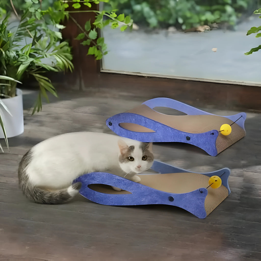 Blue fish-shaped cardboard cat scratcher lounge with a red bell toy for indoor cats.