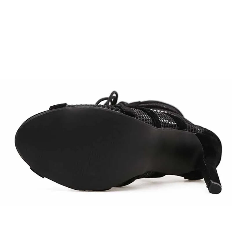 Black suede women's lace-up high heel shoes with a stiletto heel on a plain background