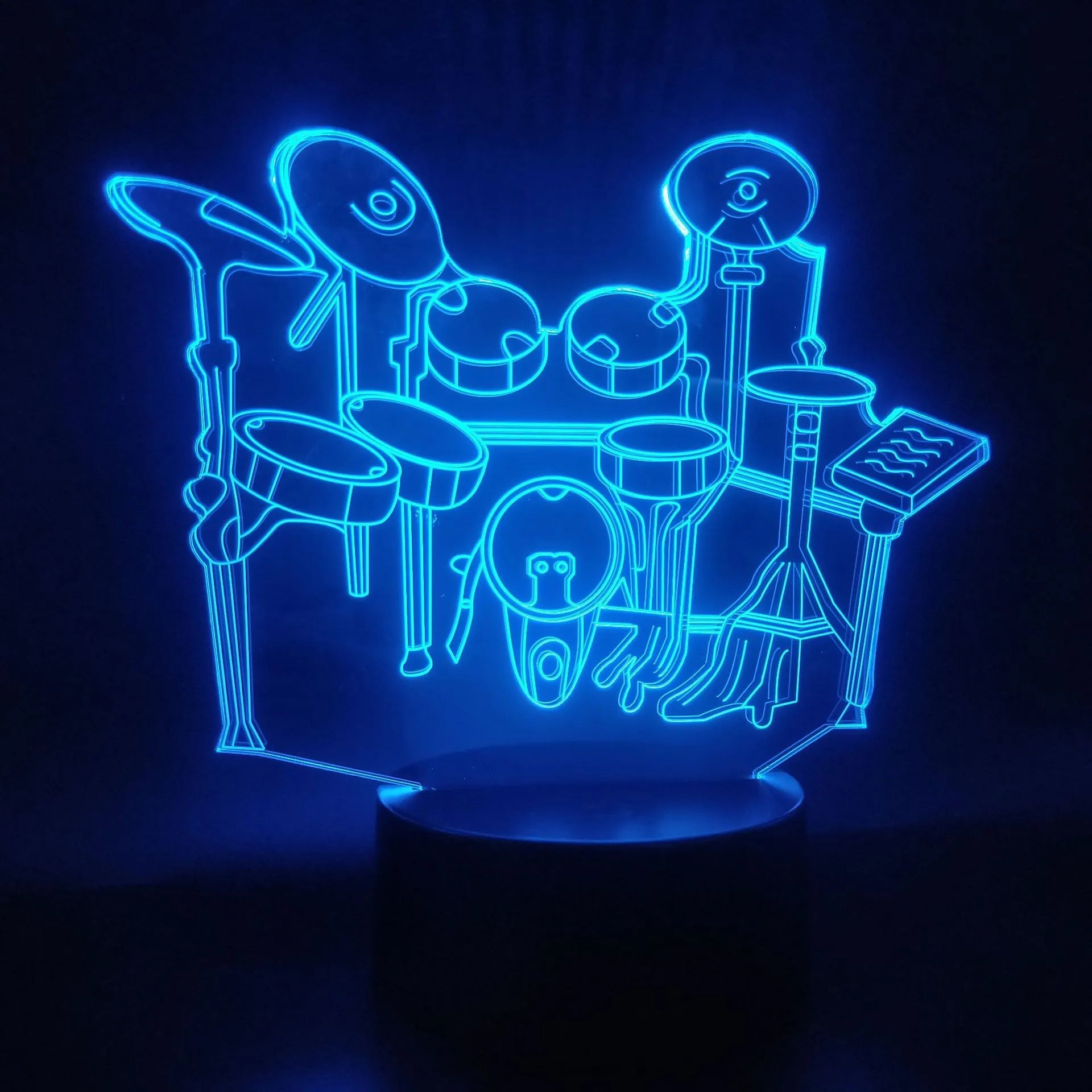 3D acrylic drum kit night light showing seven colour LED illumination on a desk