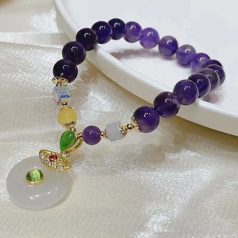 Purple amethyst bracelet with ethnic money bag pendant and peace buckle closure on wrist