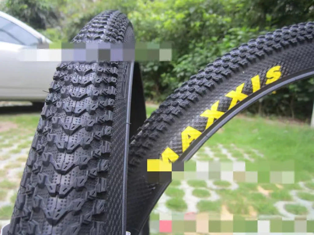 Ultralight puncture-proof mountain bike tyre in multiple sizes on a grey background.