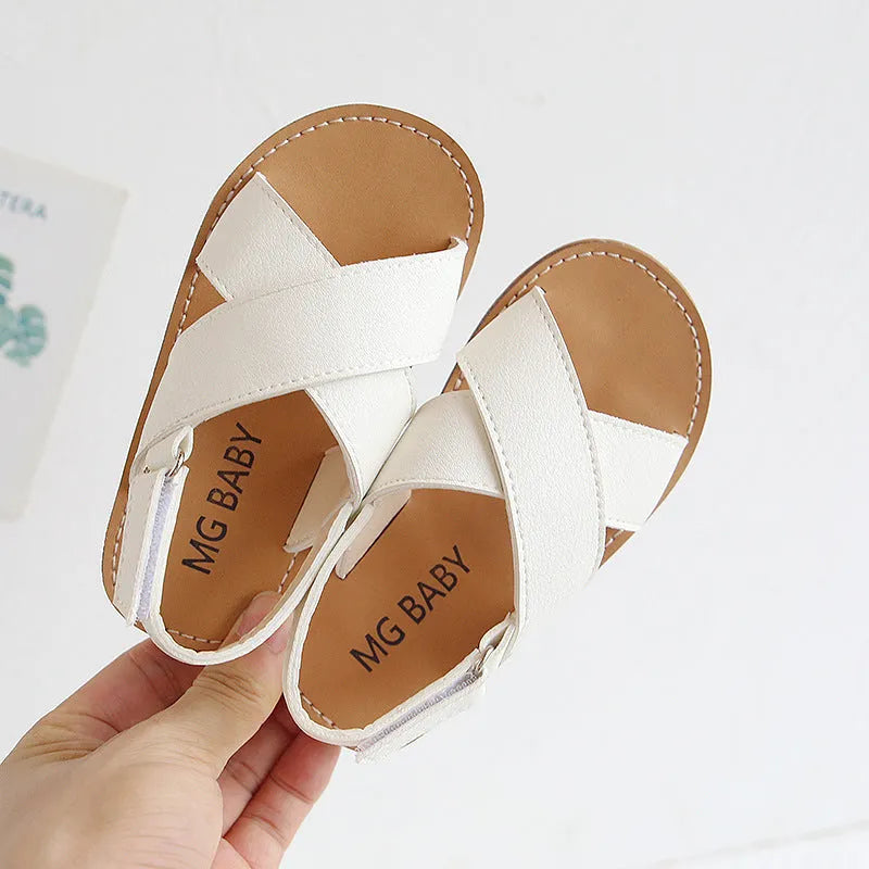 Children's cross strap Velcro sandals in brown, PU upper, beef tendon sole, side view on beach