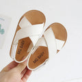 Children's cross strap Velcro sandals in brown, PU upper, beef tendon sole, side view on beach