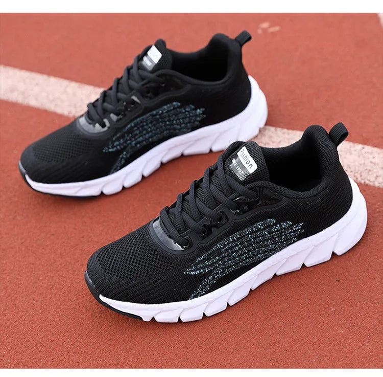 Women's low-top flat sneakers with cross-strap design in black and white colours