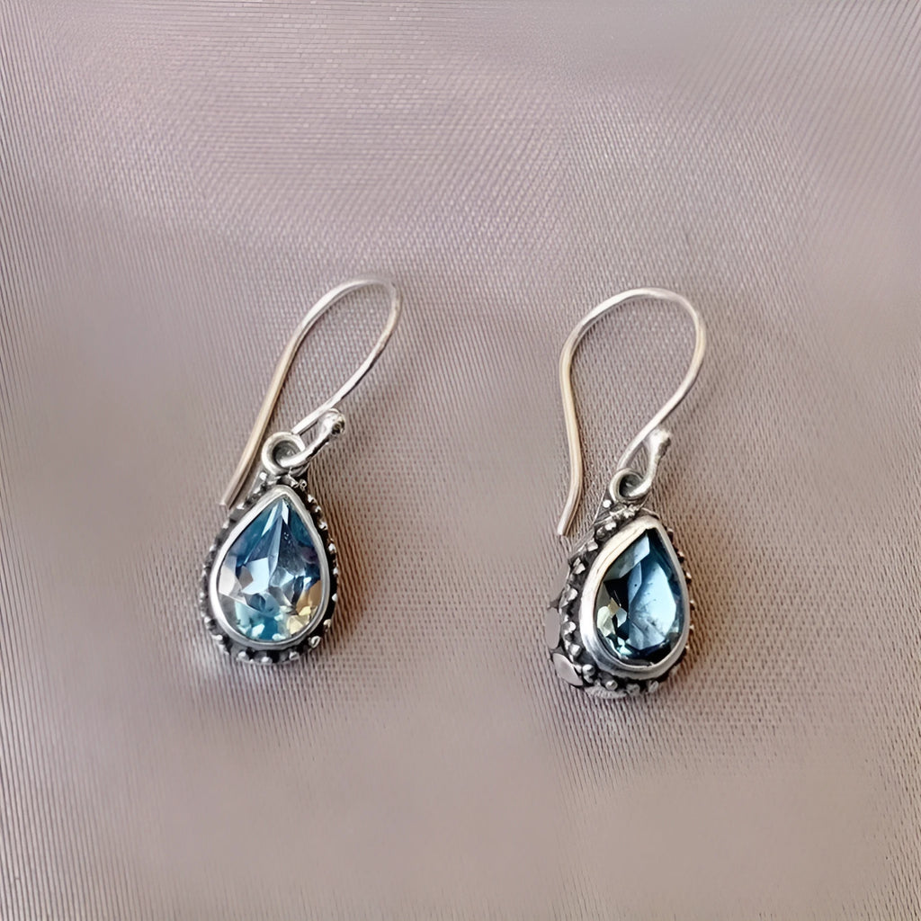 Retro style drop-shaped blue gem inlaid earrings in silver alloy, unisex jewellery on display