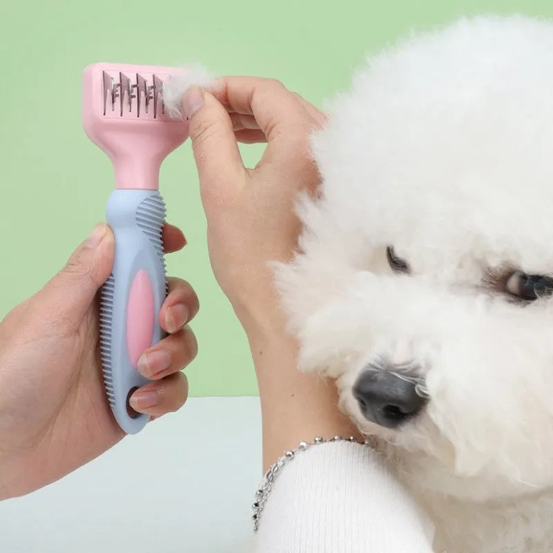 Pink dual-sided dog grooming comb with stainless steel blade and rotating ball-tip massage brush.