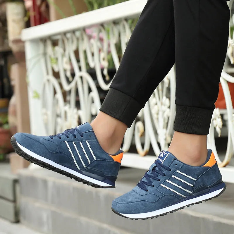 Men's blue pigskin leather sneakers with flat heel and rubber sole on grey background