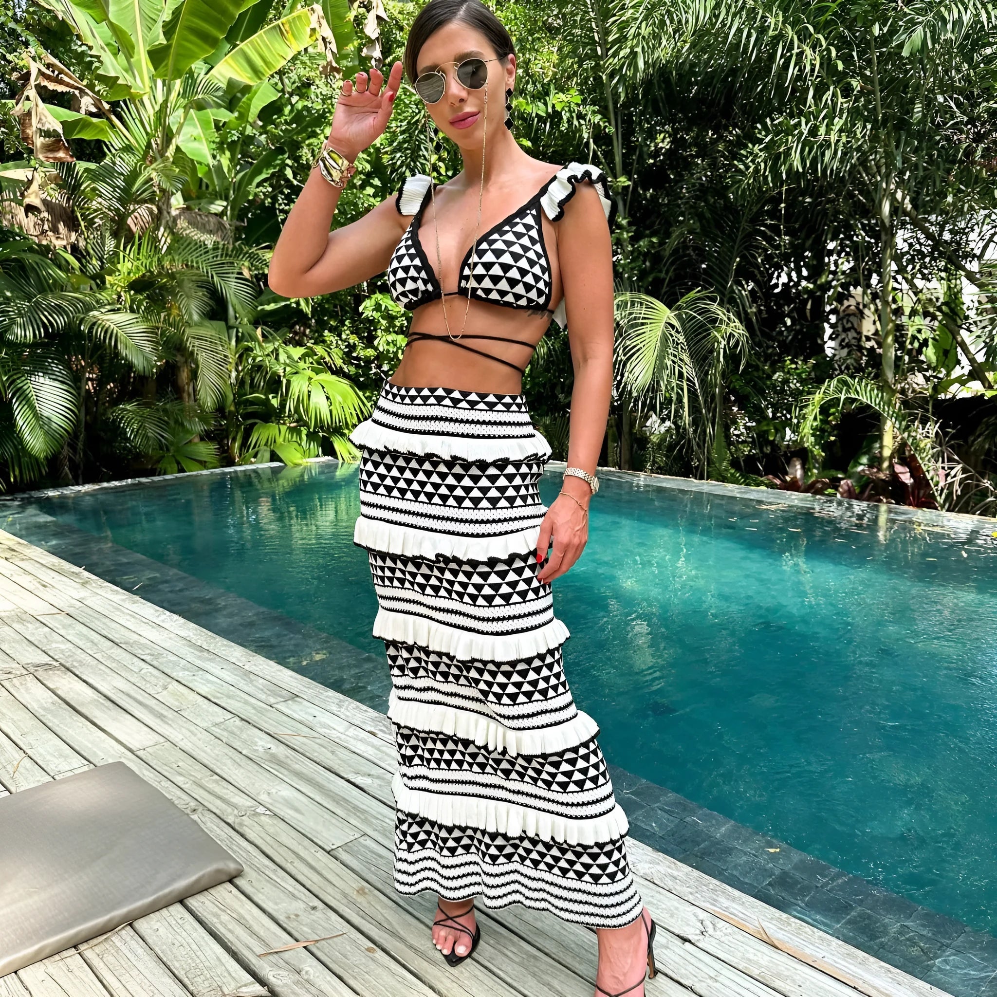 Women's black and white striped bikini top with ruffled straps and matching knitted skirt set