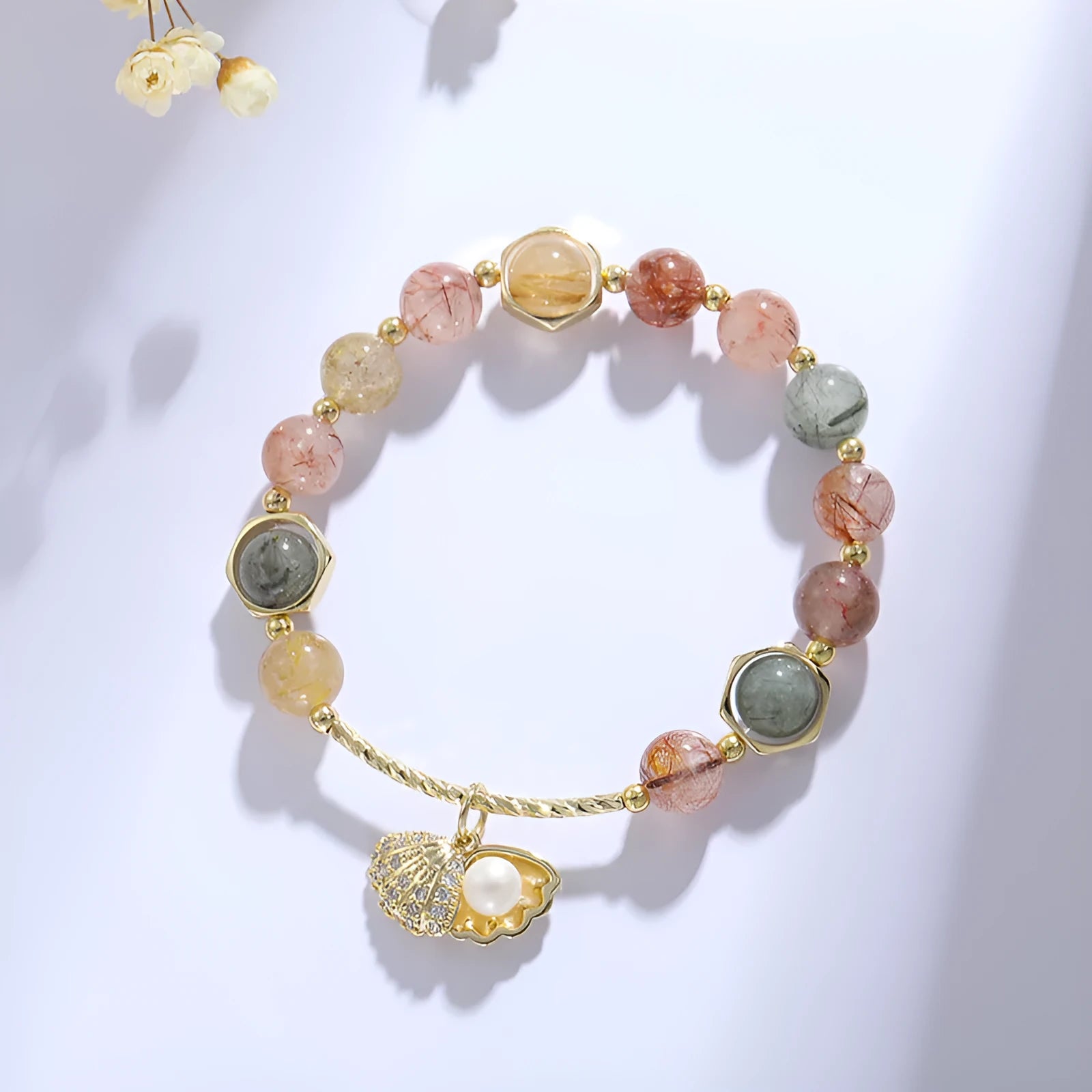 A women's crystal bracelet with colourful hair crystal shells and a red sealant flower shell on an electroplated band.