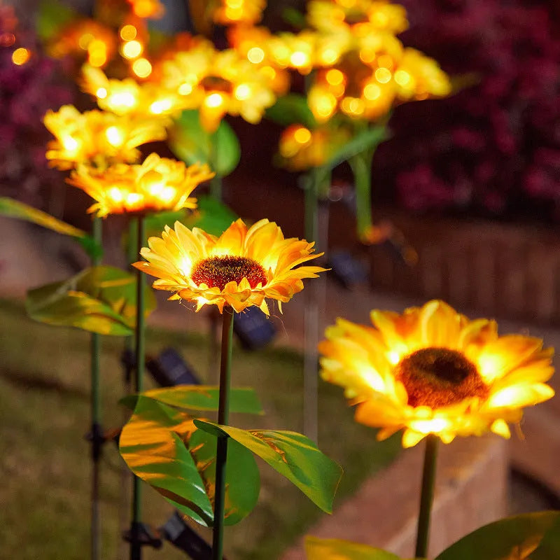 Solar sunflower lawn lamp with three sunflower heads on stainless steel stem in garden