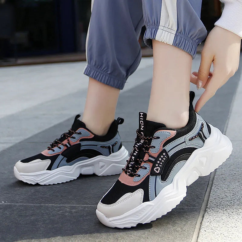 White women's casual sneaker with mesh upper, thick PU sole, buckle detail, and round toe.