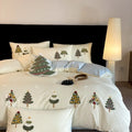 Cream blue cotton duvet cover and pillowcases with embroidered green Christmas tree and flower design.