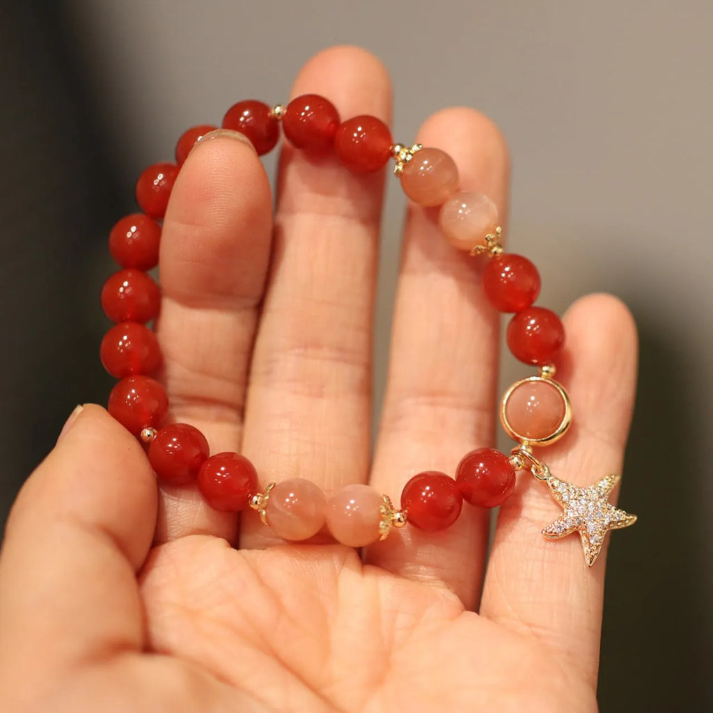 Handmade women's bracelet with 8mm red agate and sunstone beads in ethnic XINGX design featuring star and xiangyun elements