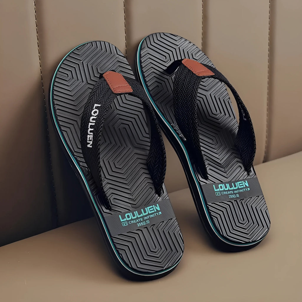 Men's black flip flops with textured non-slip PVC sole and EVA upper on a sandy beach.