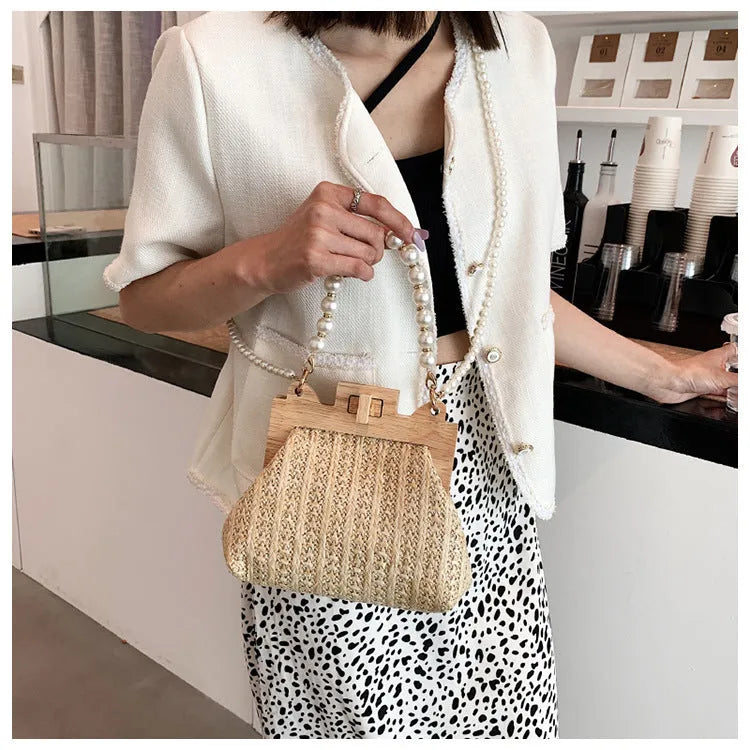 Women's woven straw shoulder bag with pearl chain detail, shown in beige, featuring internal organiser pockets.