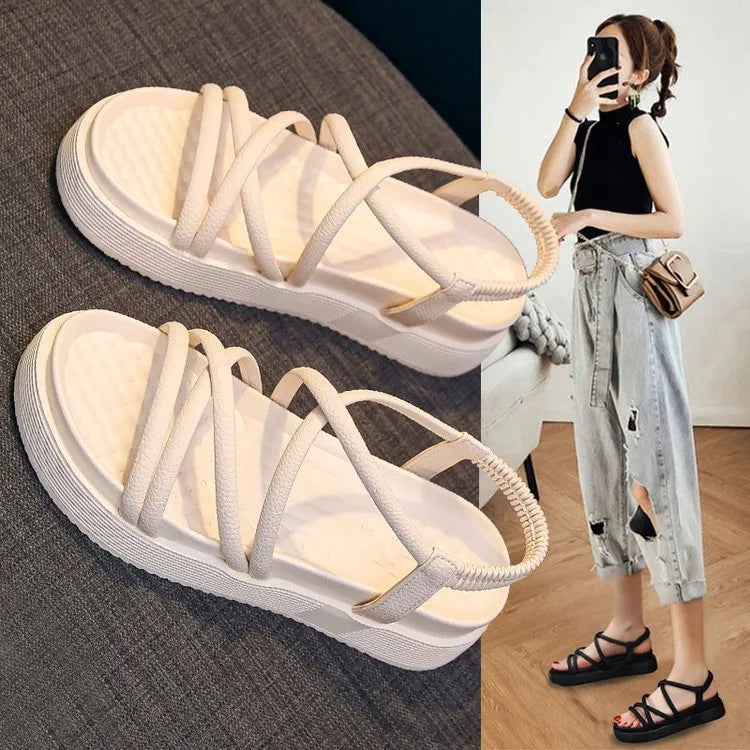 Women's black and beige Roman-style platform sandals with a round toe holder on a textured sole.